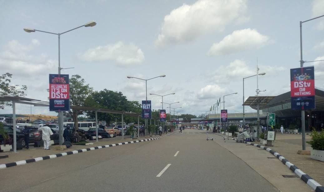 ABV-034 · Airport Lamppost — Domestic Wing Forecourt, Abuja advertising face and surrounding environment