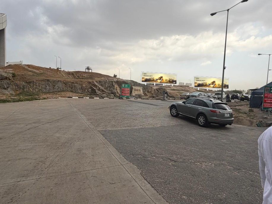 ABV-016 · Static Billboard, Nnamdi Azikiwe International Airport — Domestic Carpark Hilltop 1 advertising face and surrounding environment