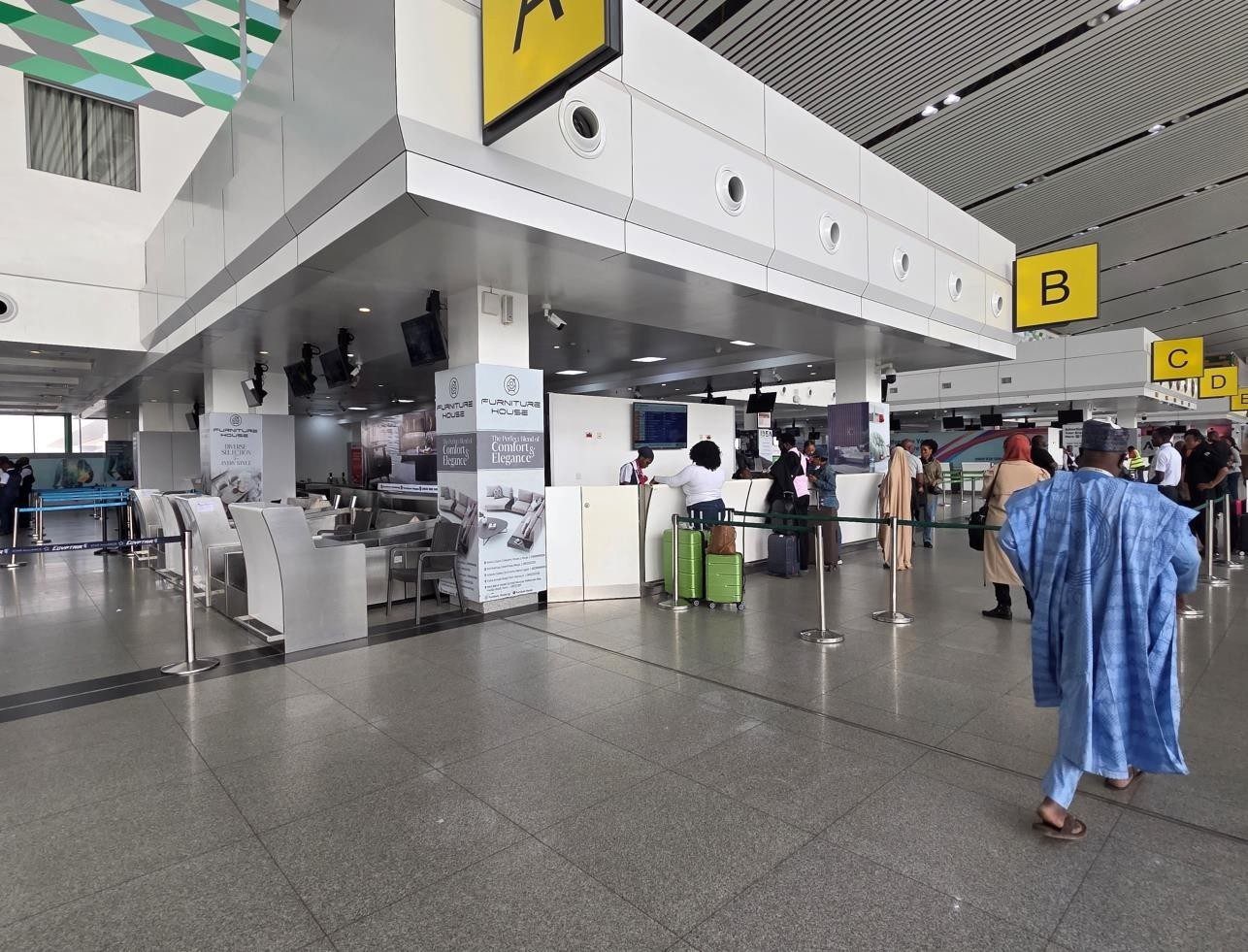 ABV-047 · Airport Static Pillar — Nnamdi Azikiwe International Airport Departure Hall (Check-In 4), Abuja advertising face and surrounding environment