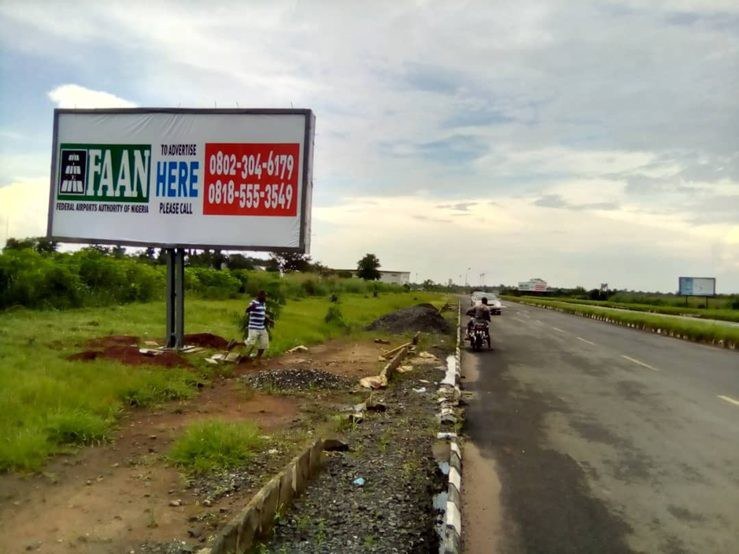 QOW-002 · Static Backlit Billboard — Near Toll Gate, Access Road advertising face and surrounding environment